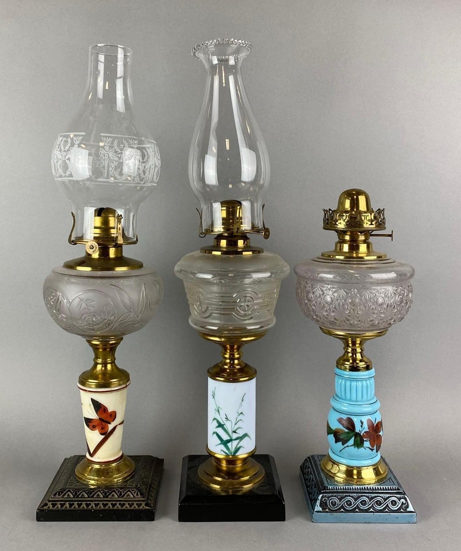 Group of 3 Antique Victorian Hand Painted Floral Motif Oil Lamps: Wear consistent with age. 2 include chimneys. Largest measures 21 x 6 x 6 inches.