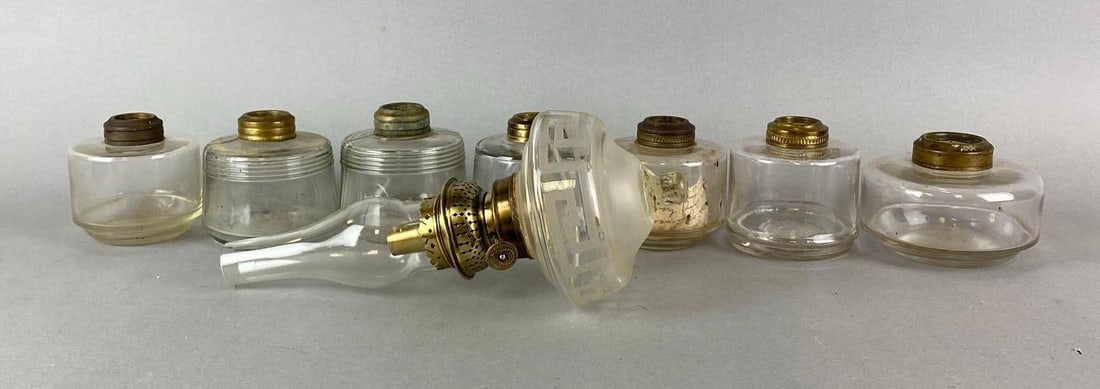 Group of 8 Antique Oil Lamp Fonts: One includes burner and chimney. Largest item measures 10 x 5 1/2 x 5 1/2 inches.