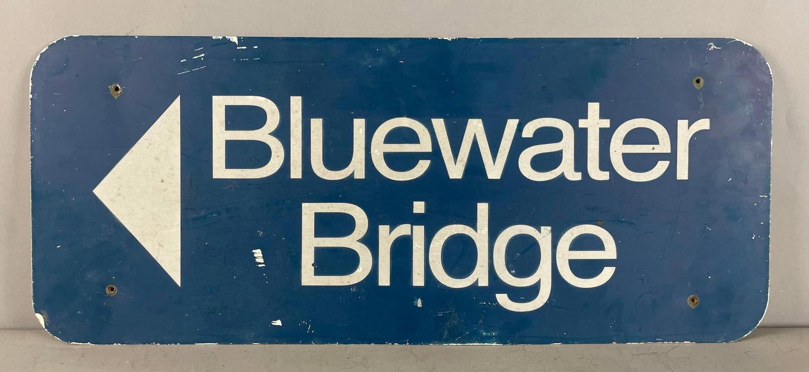 Bluewater Bridge Arrow Metal Sign: Crossing point between Canada and Michigan, measures 10" x 24"