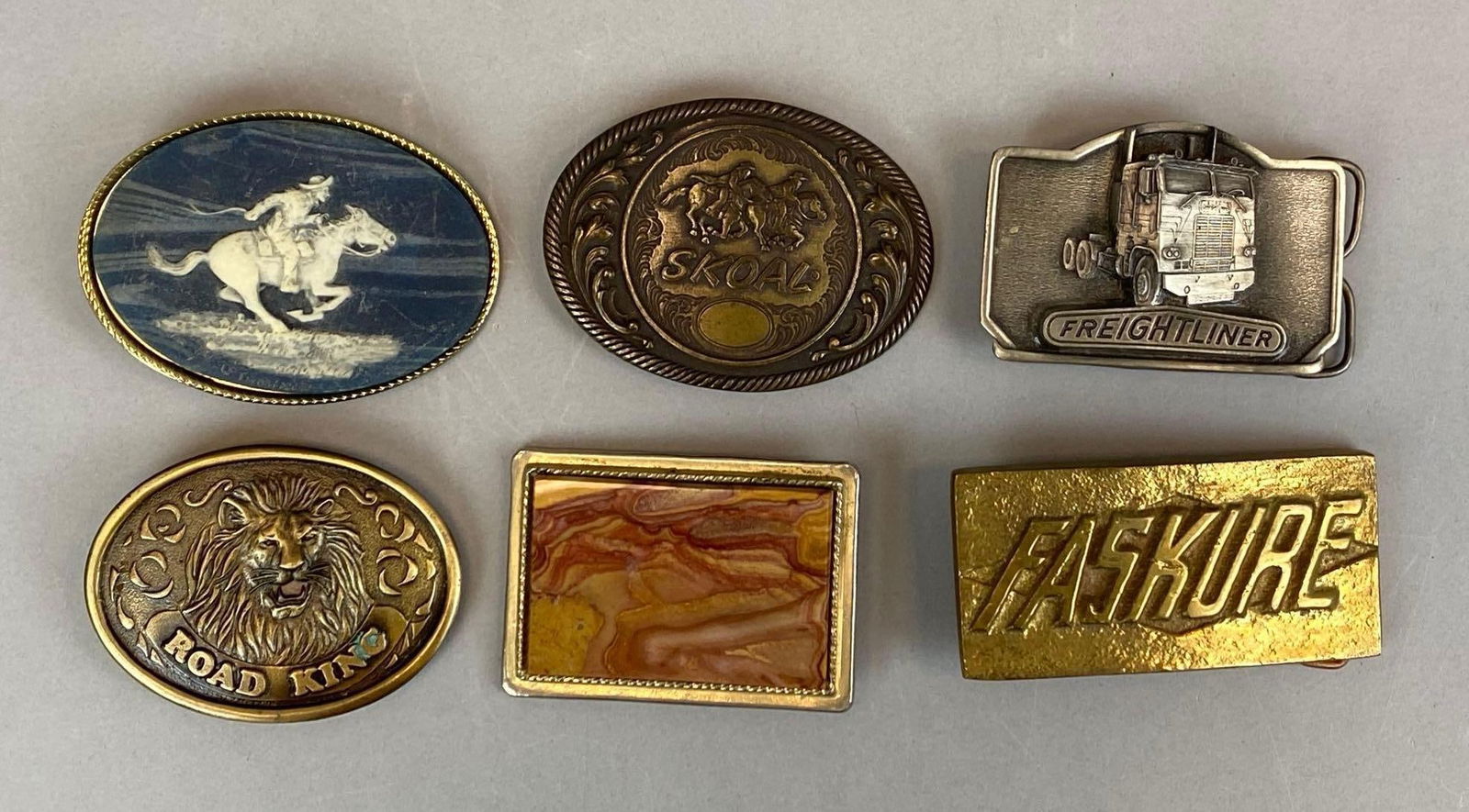 Group of 6 Vintage Belt Buckles: Includes road king, skoal, fasKure and more, 2 face emblems not attached, largest measures 2” H x 4” W