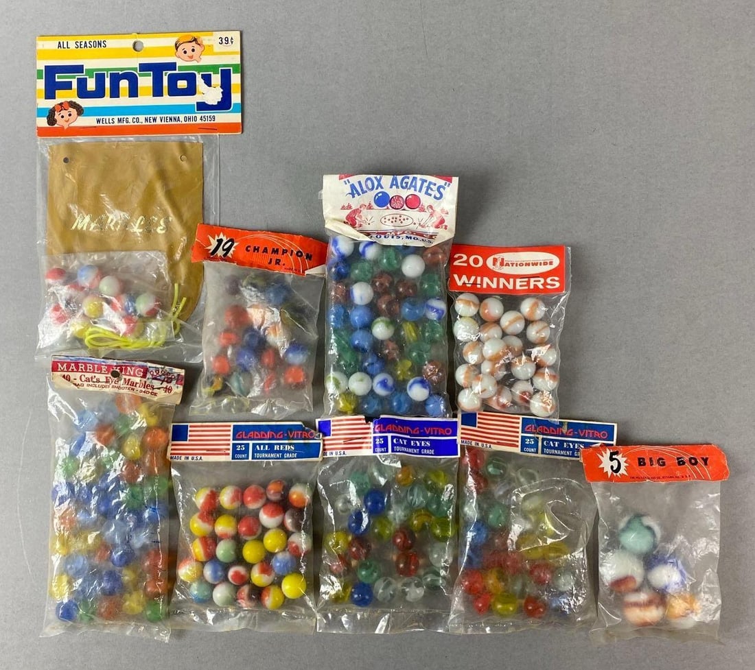 Group of 9 Sealed Packaged Marbles: Includes Champion Jr Peltier Ottawa, Illinois, Gladding Vitro, Marble King and more. Largest package measures H9 x W4 1/2 x D1 inches