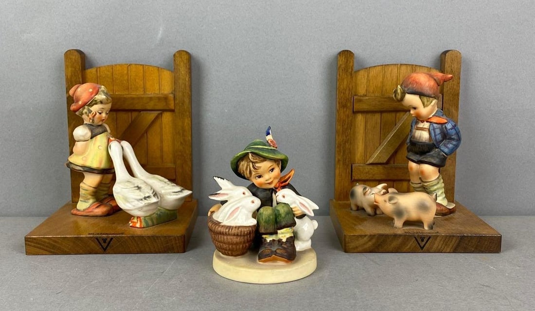 Group of 3 Hummel Porcelain Items: Includes farm boy and Goose girl bookends and playmates. Largest item measures H 6x W 4 1/2 x D 4 1/4 inches.