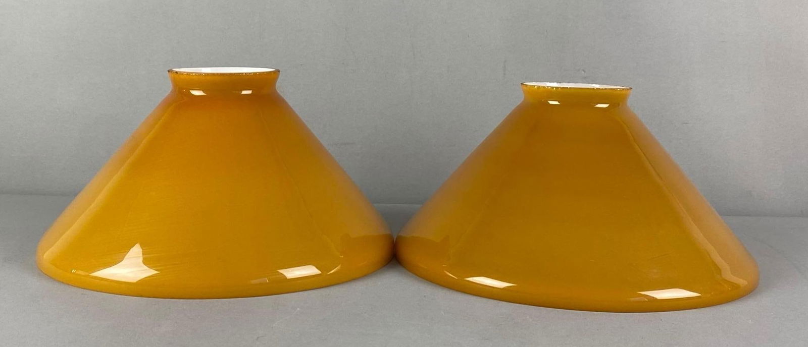 Group of 2 Antique Amber Cased Glass Lamp Shades: some chipping on top fitters, each measures 5” H x 9 3/4” W with a 9 3/4” Fitter