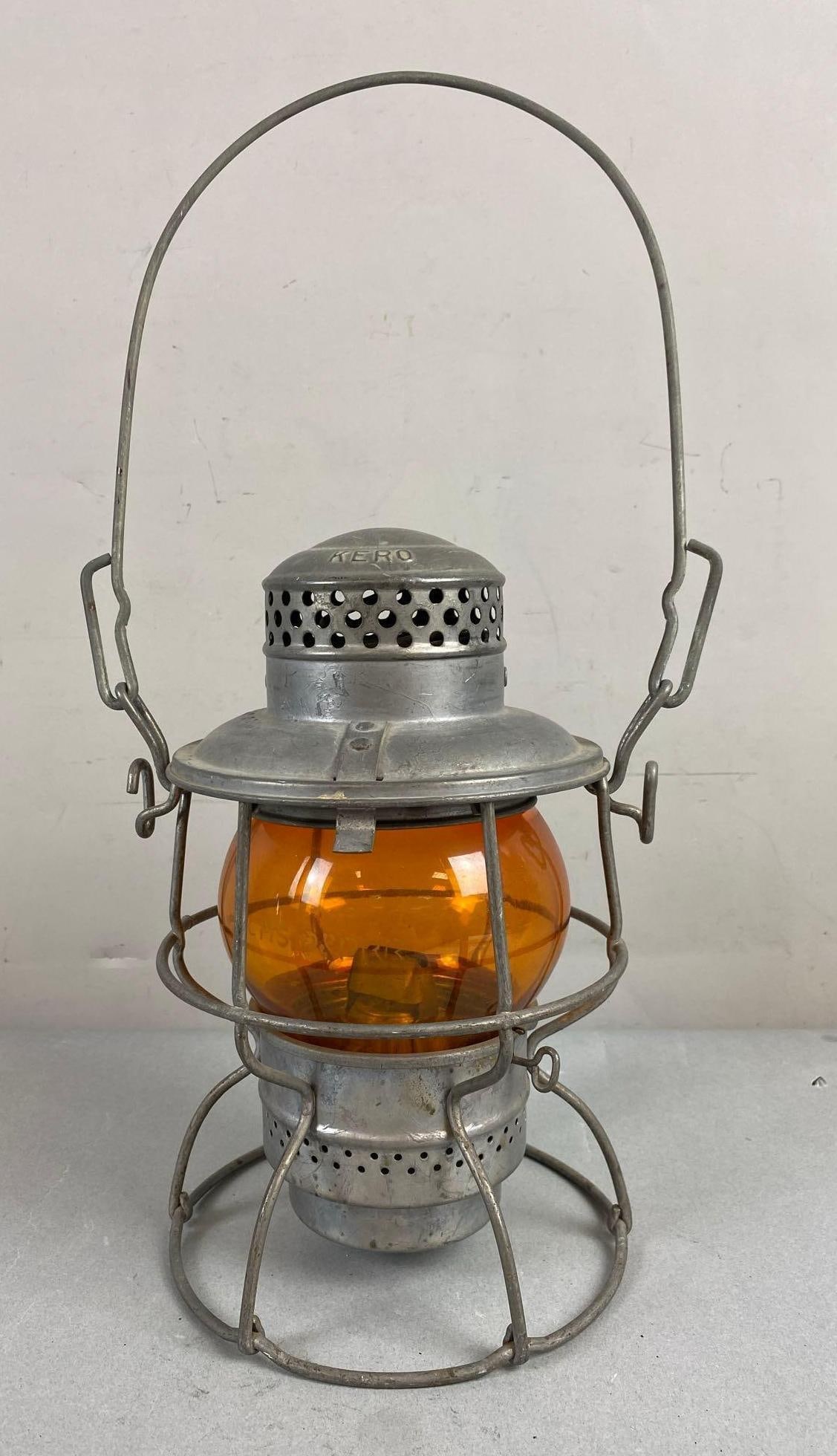 Vintage Adlake Kerosene Oil Lantern: CMS & St. P. PRR etched on orange Globe. Measures 9 1/2 inches tall.
