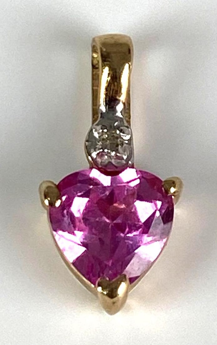 Signed 10K Yellow Gold Pink Sapphire Heart Pendant: total weight of 0.4 grams, measures 1/2” H