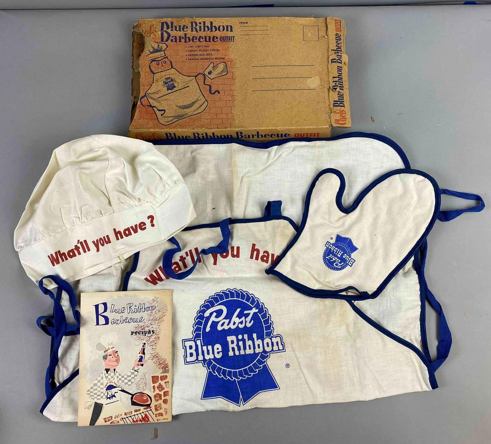 Pabst Blue Ribbon Barbecue Outfit: Like new in original packaging. Has some stains and packaging has rips and tears. Box measures H 1 x W 7 x L 12 inches. Circa 1960’s.