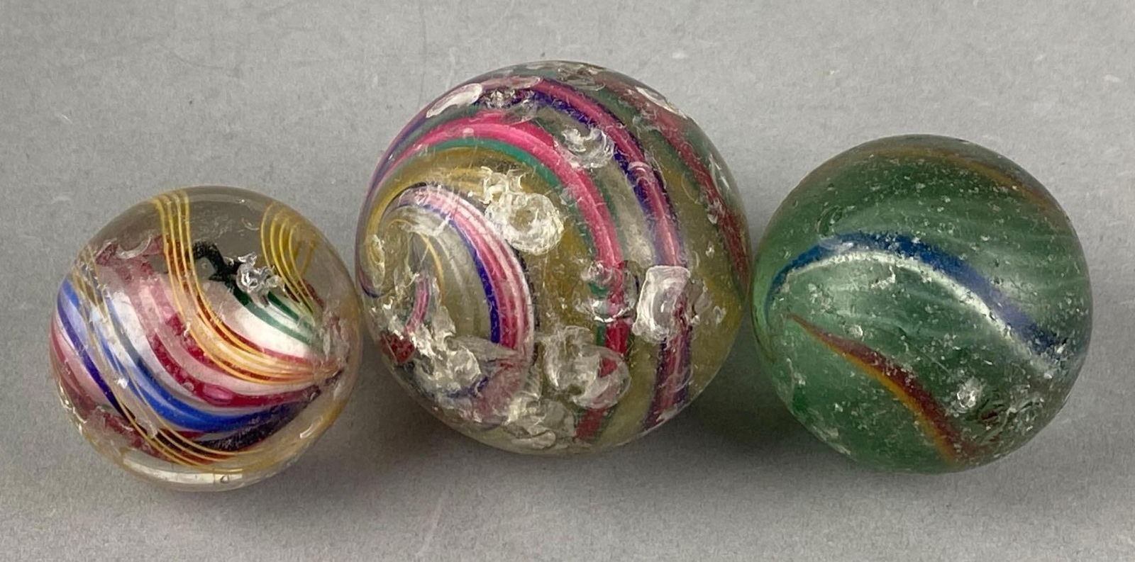 Group of 3 Vintage Glass Marbles: bruises and chips throughout, largest measures 2.35”