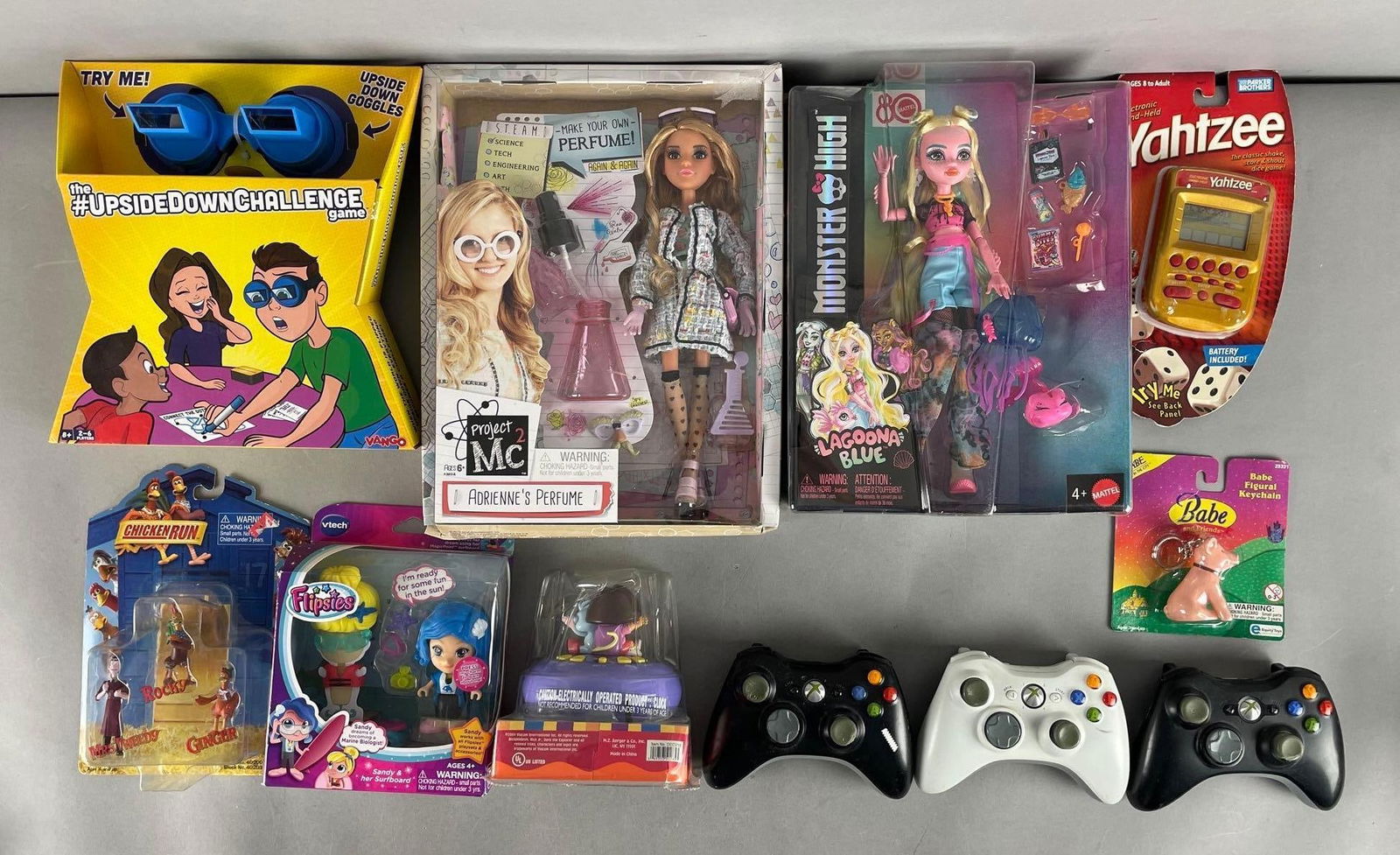 Group of Figures and Xbox Controllers: Includes Dora alarm clock, games, monster high lagoona blue doll
