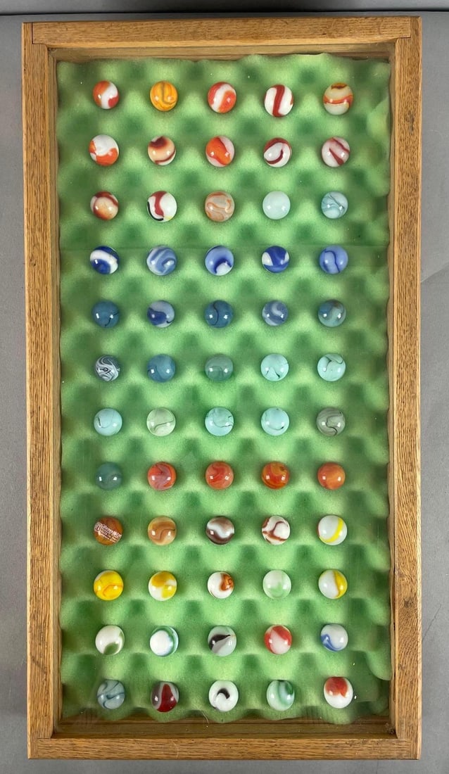 Group of 60 Vintage Glass Shooter Marbles with Display Case: 7/8" shooters, oak and glass case measures 24 1/4" x 13" x 2 3/4"