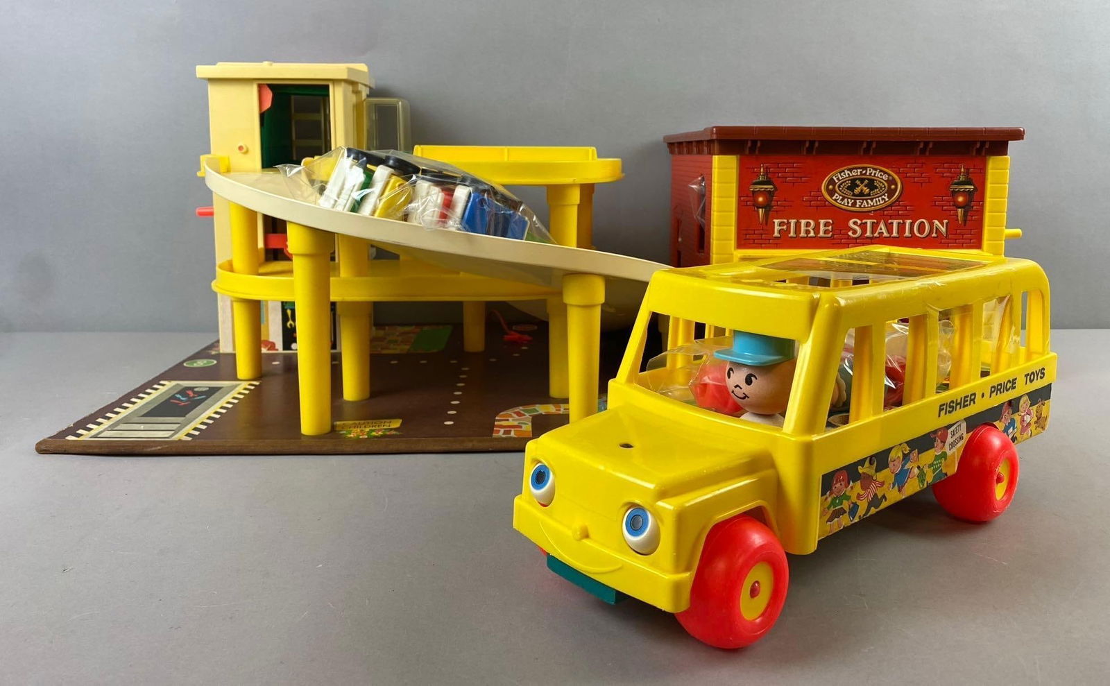 Group of Assorted Fisher Price Play Family Playsets: Include parking Garage, fire Station, and more. Largest measures H 10 x W 15 x L 17 inches.