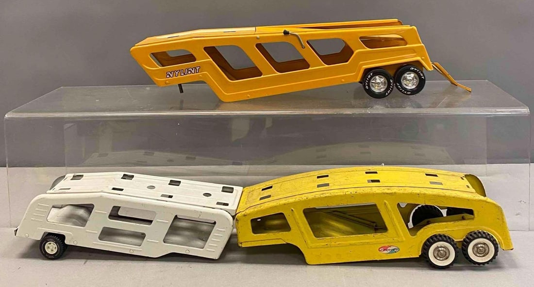 Group of 3 Press Steel Vehicles Trailers: Includes Nylint, Tonka, and Structo. Largest measures H 5 x W 5 x L 22 inches. Stand not included.