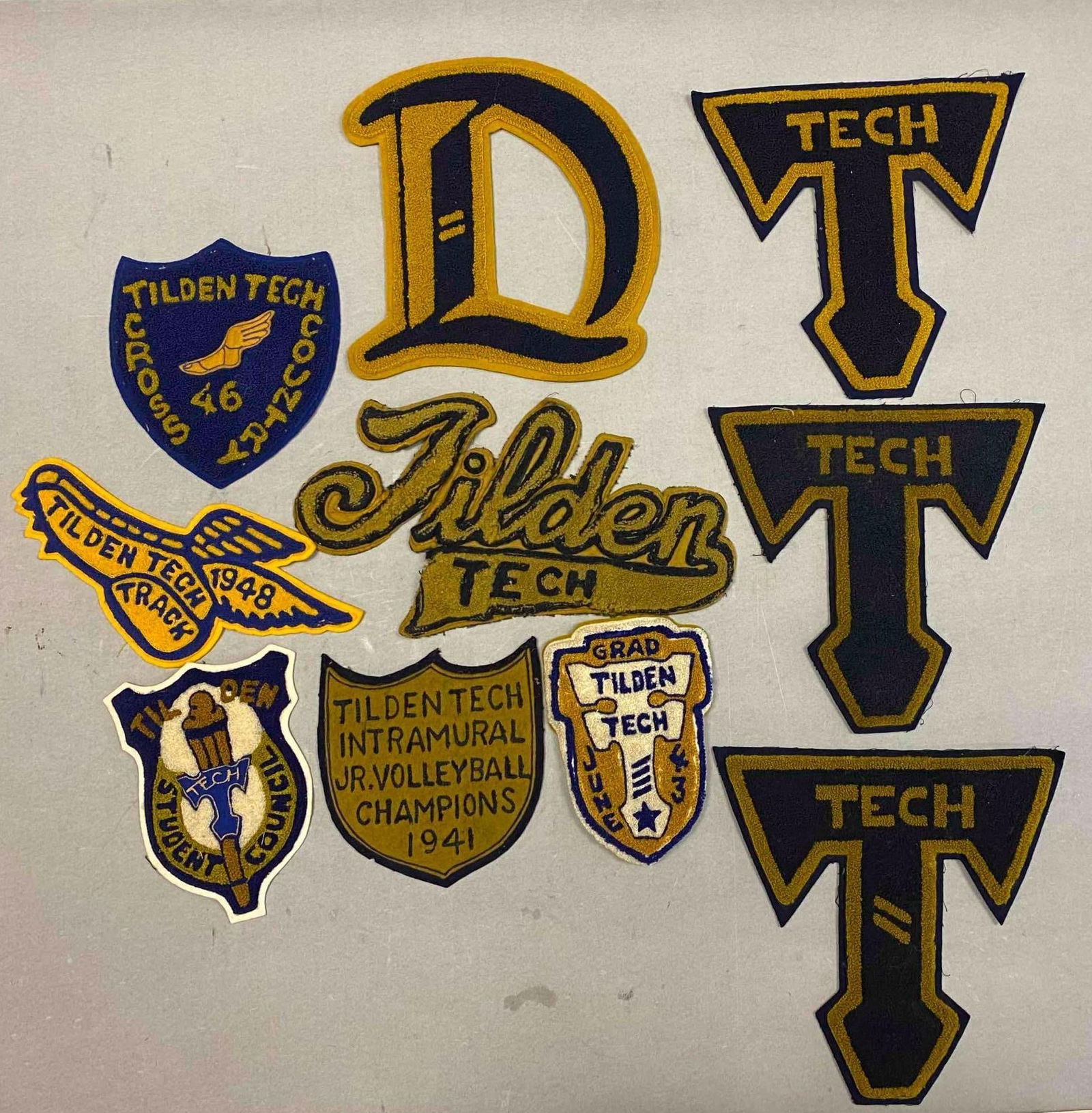 Group of Assorted Vintage Tilden Tech School Varsity Patches: Includes Cross Country, Track and Field, and more. Largest patch measures L 8 1/2 x W 8 1/2 inches.