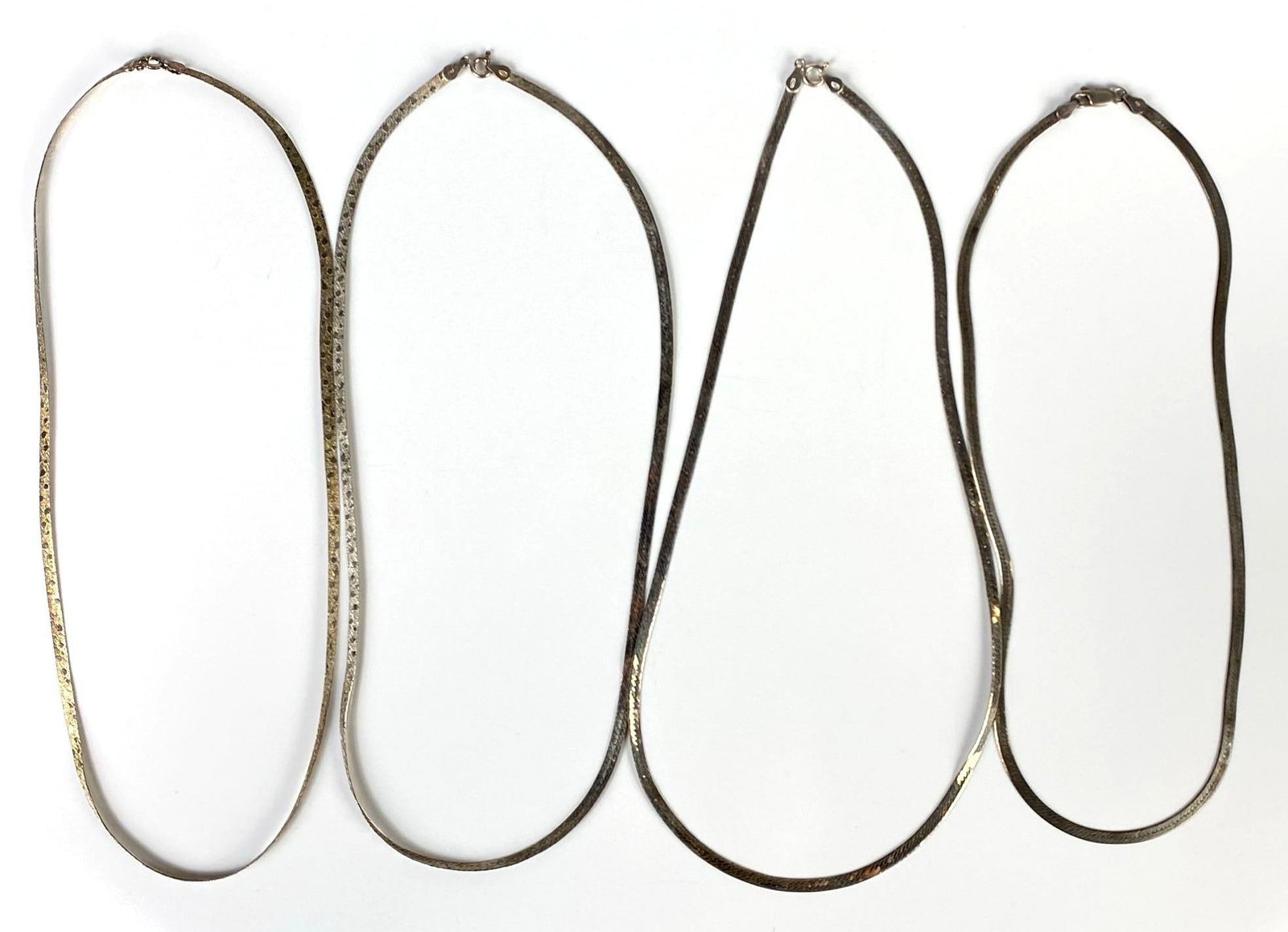 Group of 4 Sterling Silver Herringbone Chain Necklaces: Longest measures 20 inches long.