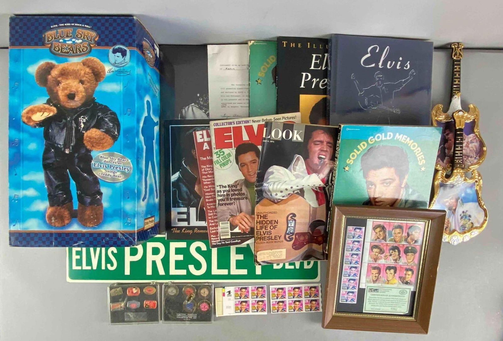 Group of Assorted Elvis Items: Includes singing teddy bear, stamps, magazines and more, largest measures 15 1/2” H x 9 1/2” W x 6 1/2” D