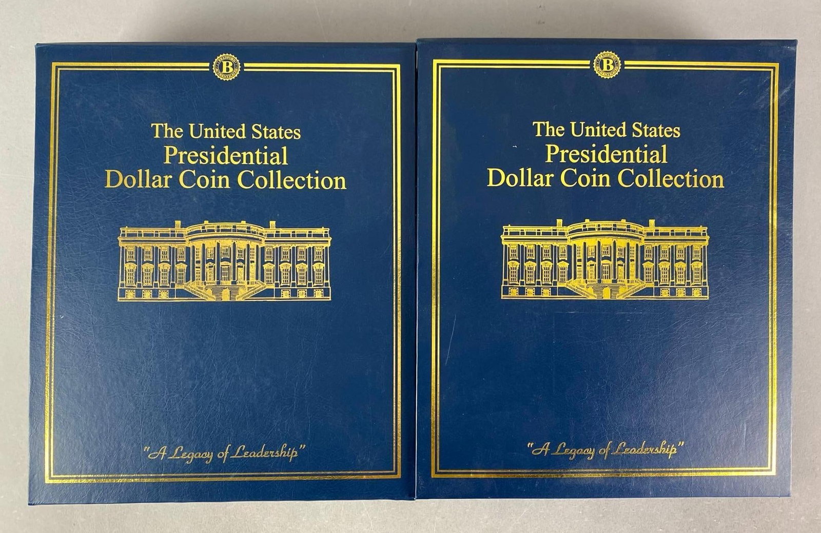 2 Volume Set Of The US Presidential Dollar Coin Collection: Includes 39 pages featuring presidents with their respective coins, ranging from George Washington to Ronald Reagan, missing Jimmy Carter, each album measures 13 1/2” H x 11” W