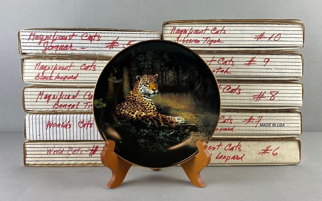 Group of 10 The Bradford Exchange Magnificent Cats Plates: Complete set 1-10 that include Black Leopard, Siberian Tiger, and more. Like new in original packaging. One plate measures 8 1/2” in diameter. Stand not included.