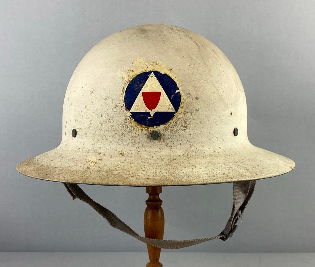 WW2 US Civilian Defense Helmet and First Aid Book: Helmet measures L 13 1/2 x W 6 inches. Stand not included.