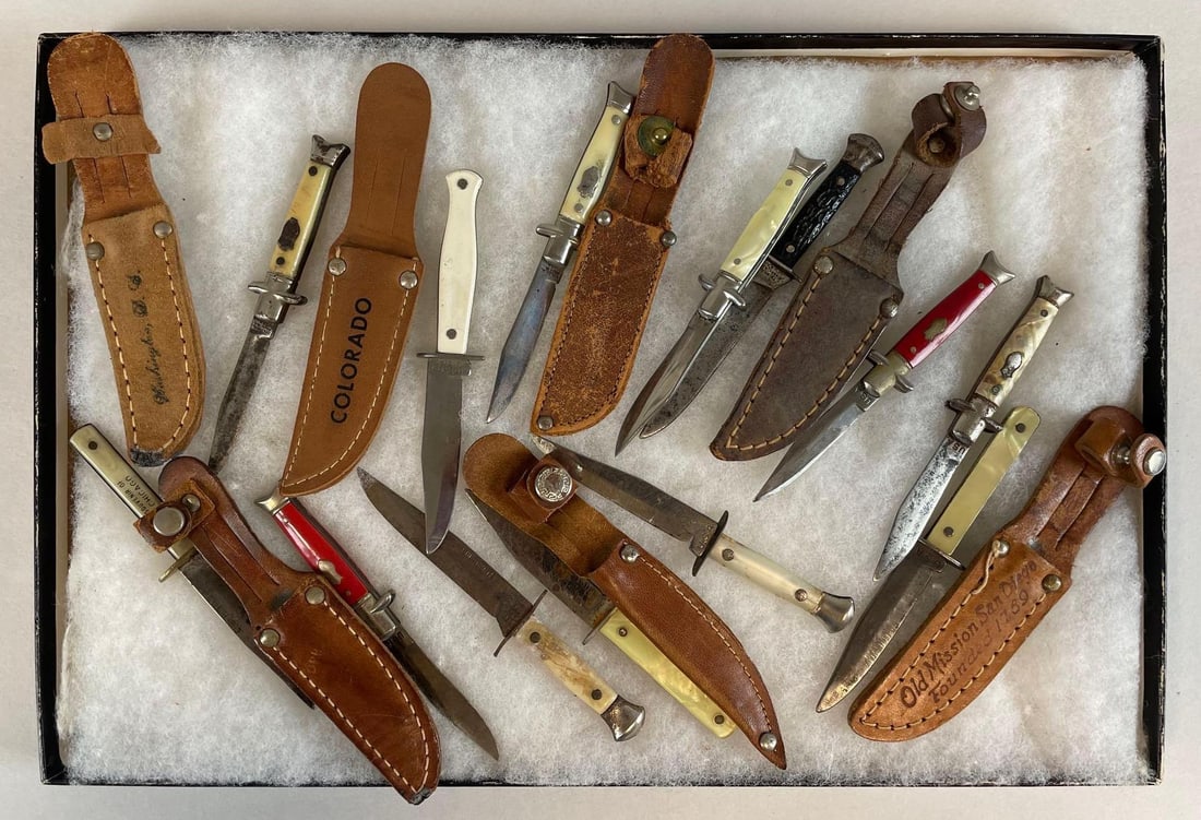 Group of Vintage Miniature Fixed Blade Knives: Includes sheaths, souvenir, cub hunter, mother of pearl, riker case measures 8 1/4" x 12 1/4"