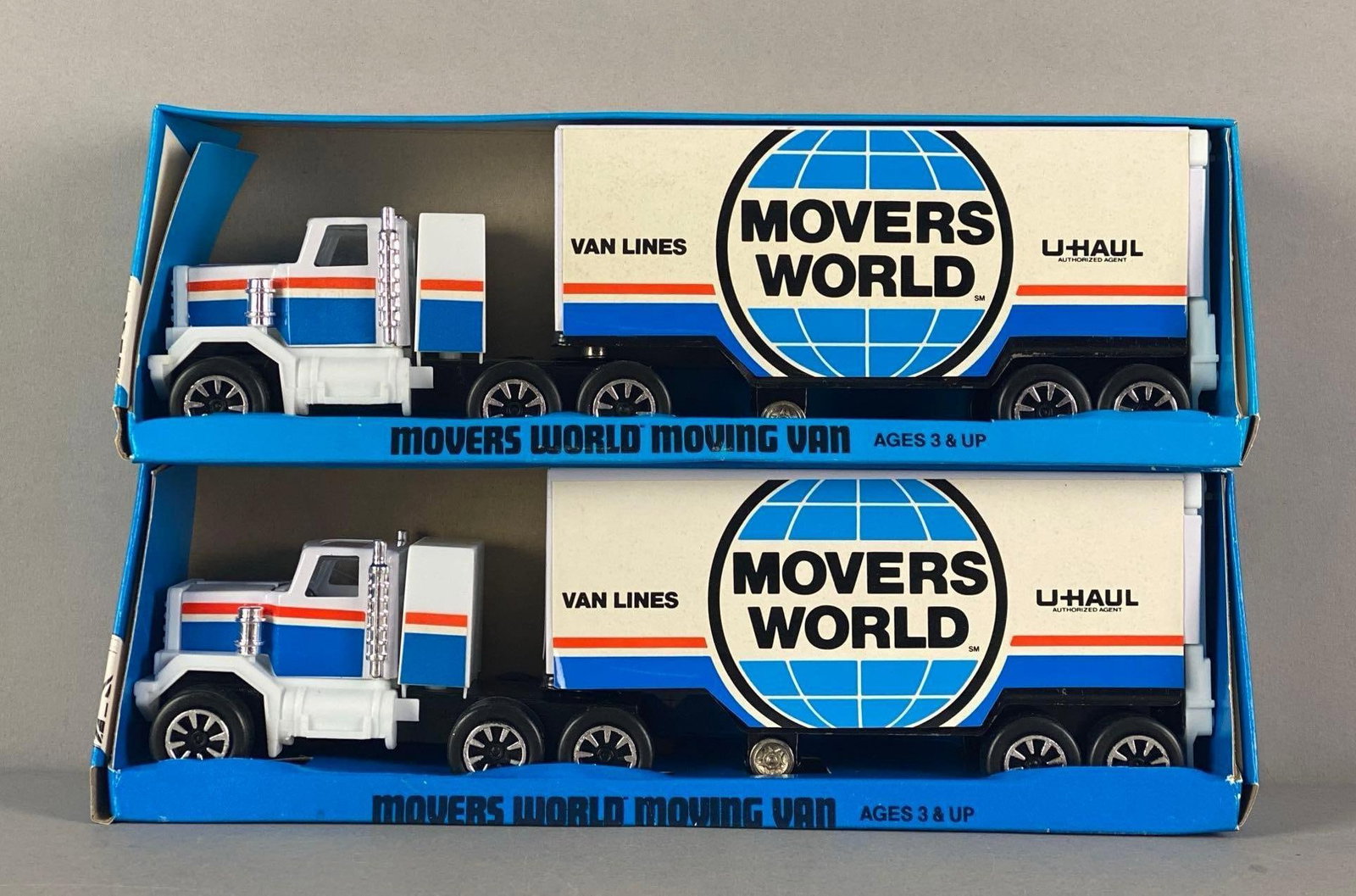 Group of 2 Movers World Moving Vans: In original packaging, die-cast, 1/64 scale