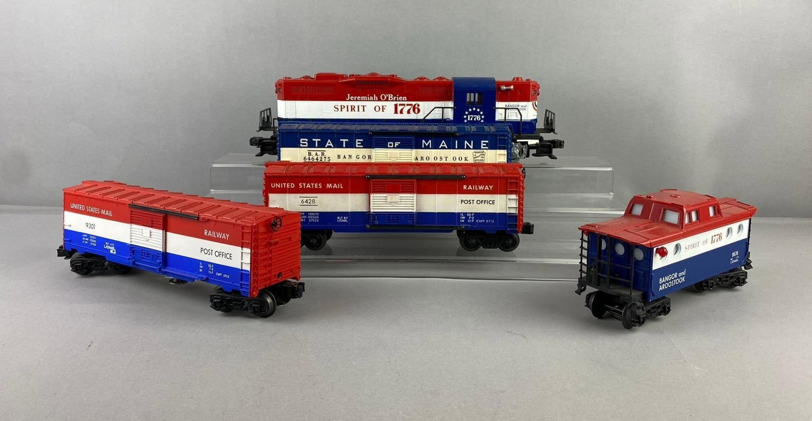 Group of 5 Lionel Trains O Gauge Spirit of 1776 Diesel Locomotive and More: Group of 5 Lionel Trains O Gauge Spirit of 1776 Diesel Locomotive and More, Includes Jeremiah O?Brien 1776 Bangor and Aroostook Train cars and locomotive. Untested. Locomotive measures H 4 x W 3 x L 1