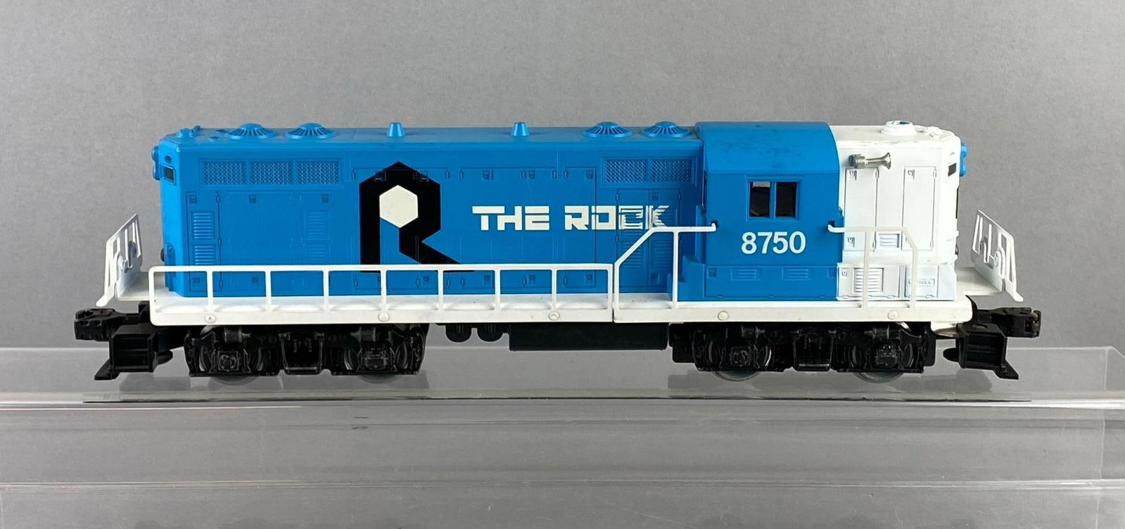 Lionel Trains O Gauge No. 8750 Diesel Locomotive: The Rock line. Untested. Measures H 4 x W 2 1/2 x L 14 inches. Stand not included.