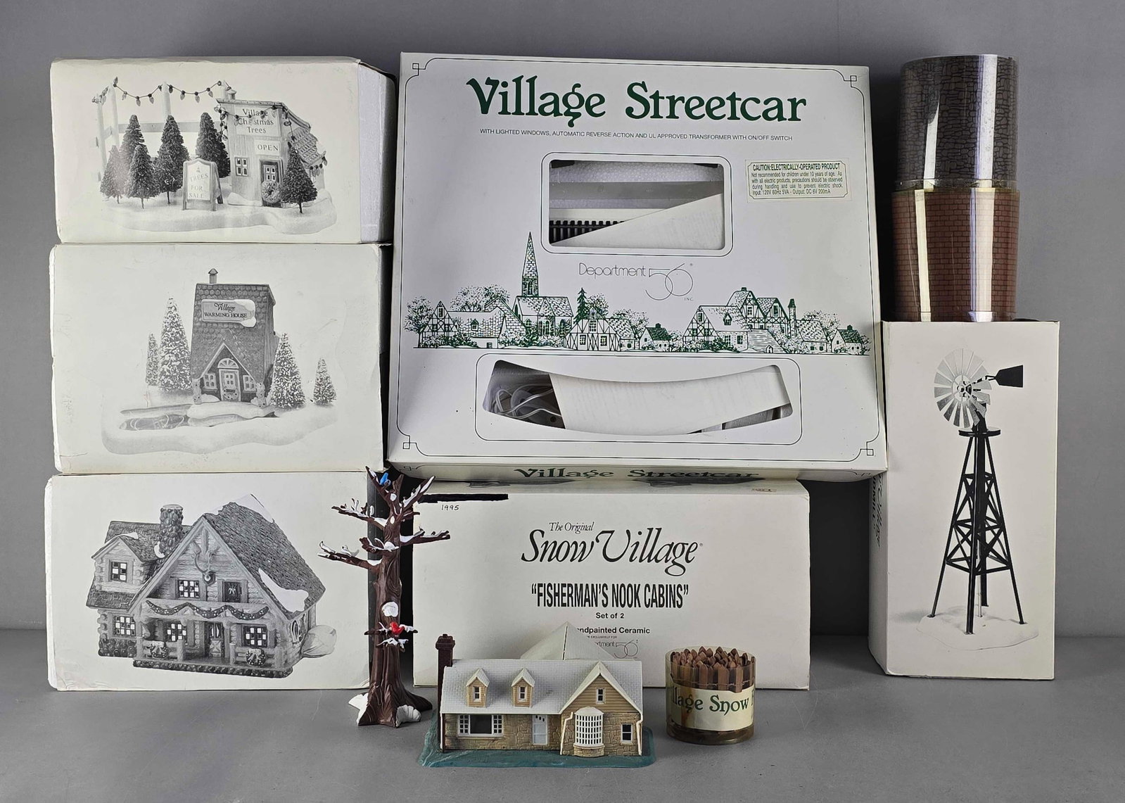 Group of Department 56 Village Accessories: Includes fisherman's book cabins, Village street car, snowy tree and more, largest box measures 16" H x 18" W x 3" D