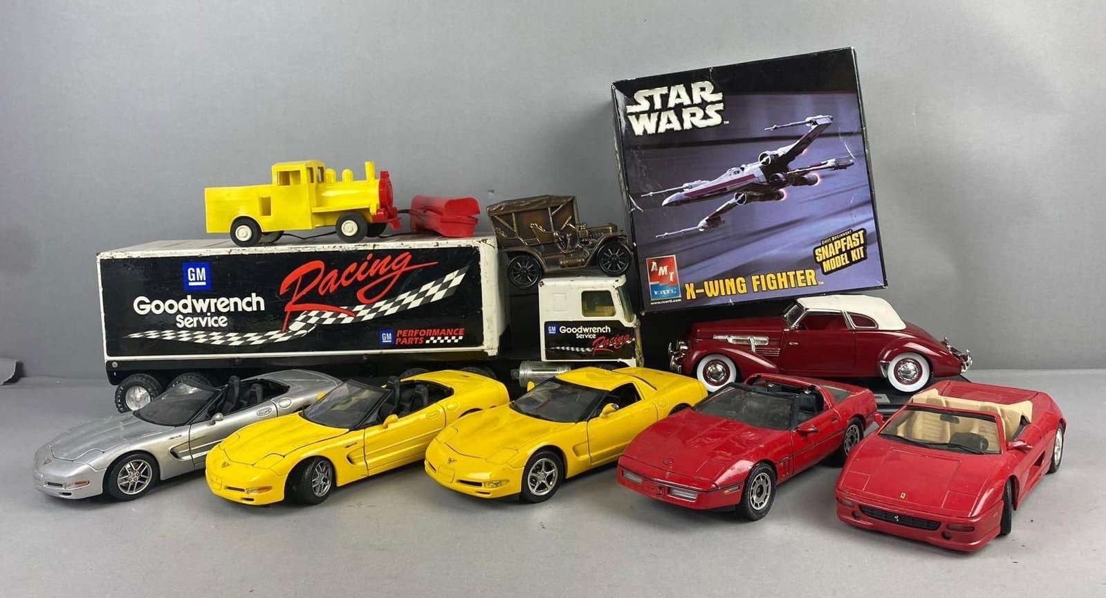 Group of 2001 Maisto Corvette 1/18 Die Cast Vehicles and More: Includes NYlint GM Goodwrench Truck and Trailer, Star Wars x wing fighter model Kit and more. Largest measures 21 inches in length.