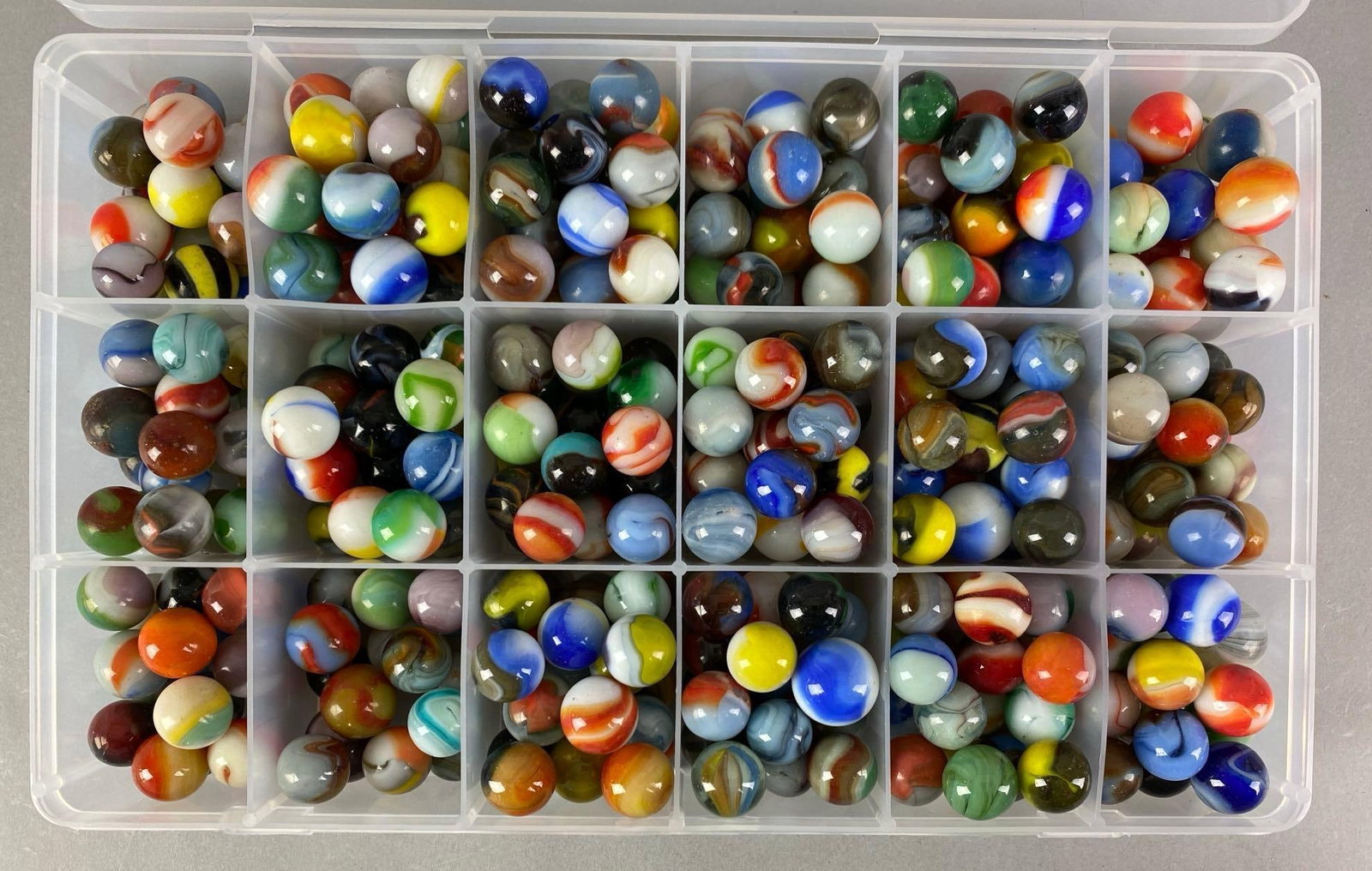 Group of Assorted Modern Glass Marbles: Case measures 7 inches H x 11 inches W x 2 inches D, largest marble measures .8 inches