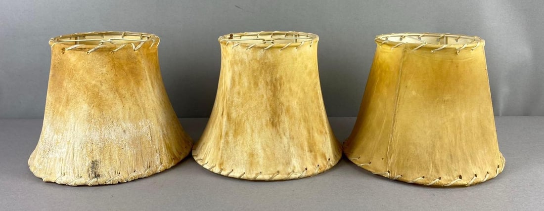 Group of 3 Vintage Rustic Rawhide Lamp Shades: One measures 6 inches tall. One has rips in rawhide.