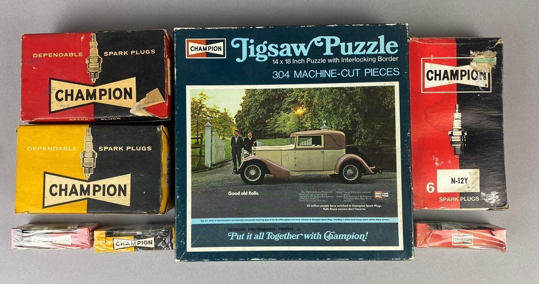 Group of Assorted Vintage Champion Spark plugs and More: Includes Empty Champion Advertising Jigsaw Puzzle. Largest measures L 8 1/2 x W 8 1/2 inches.