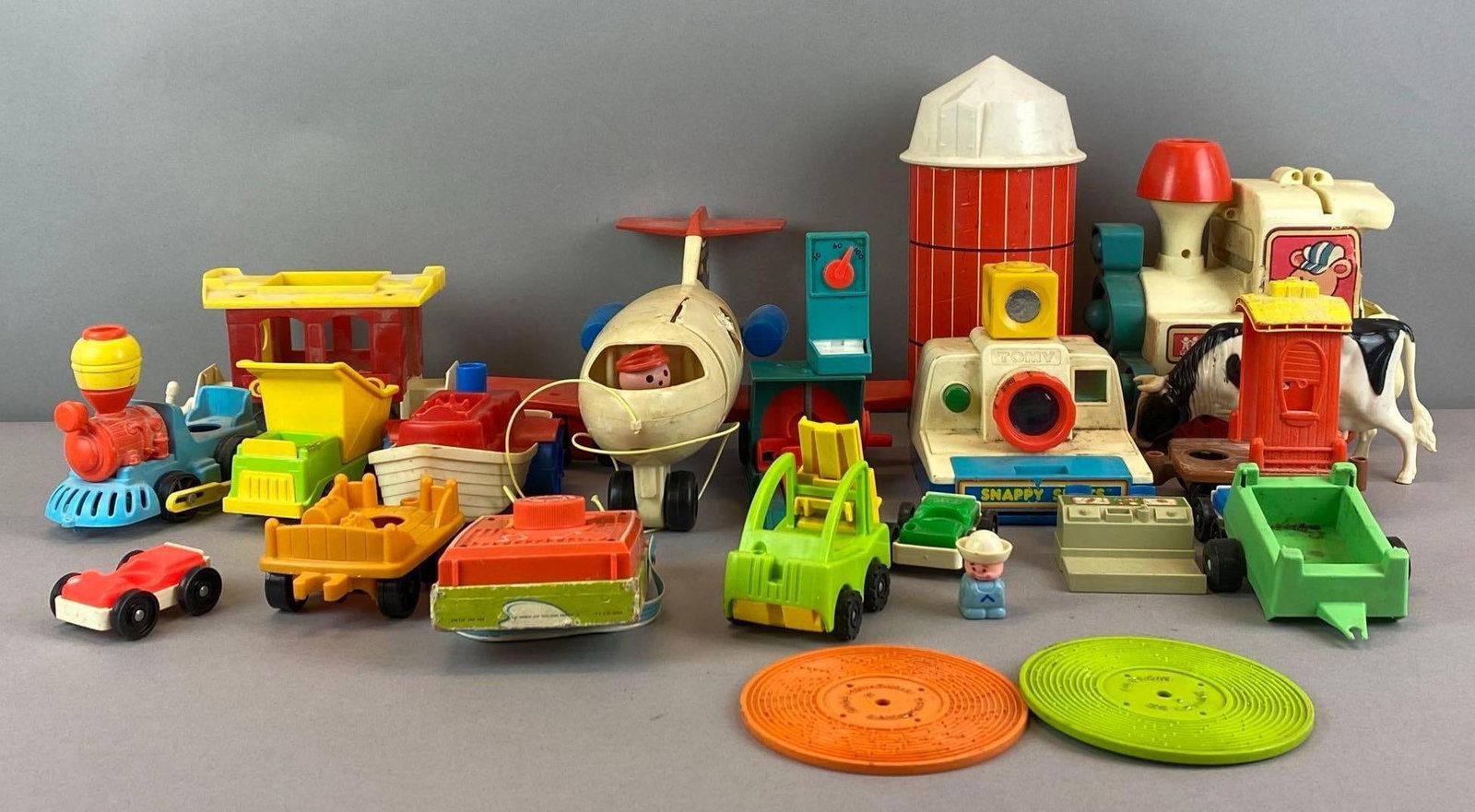 Group of Assorted Fisher Price Toys and More: Includes Tomy Snappy Shot, plastic Toy records, airplane and more, largest measures 11 inches H x 5 inches W x 5 inches D