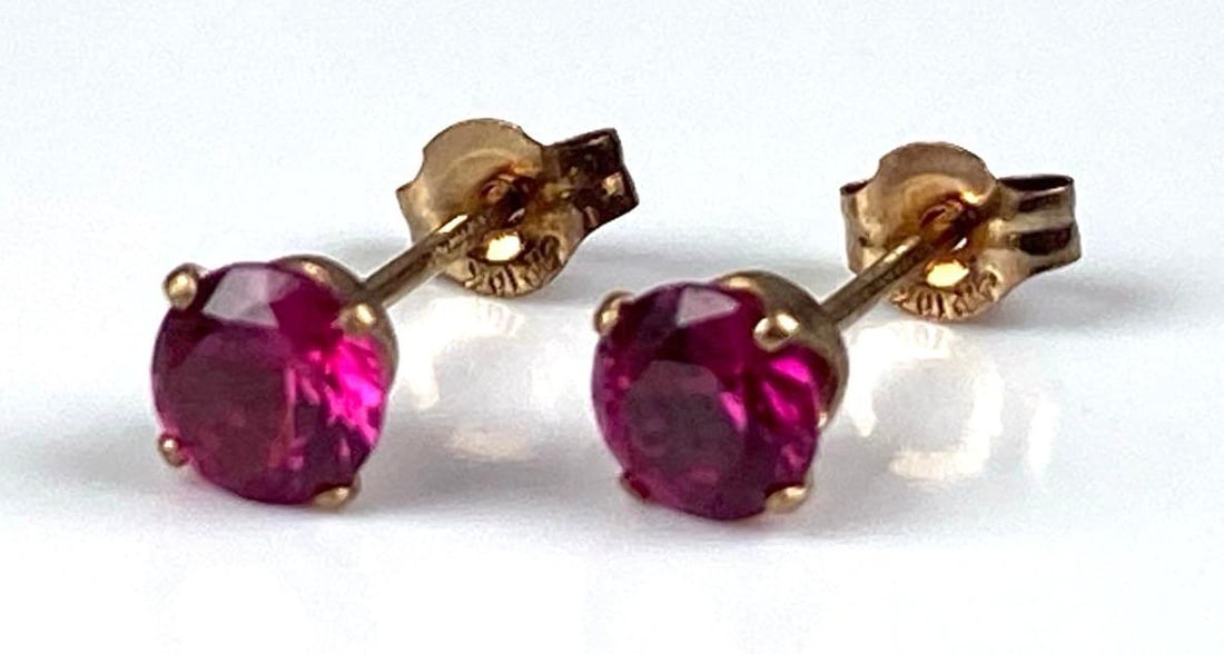 Pair of 10K Yellow Gold Ruby Stud Earrings: Total weight of 0.4 grams, each measures 1/2 inches in length