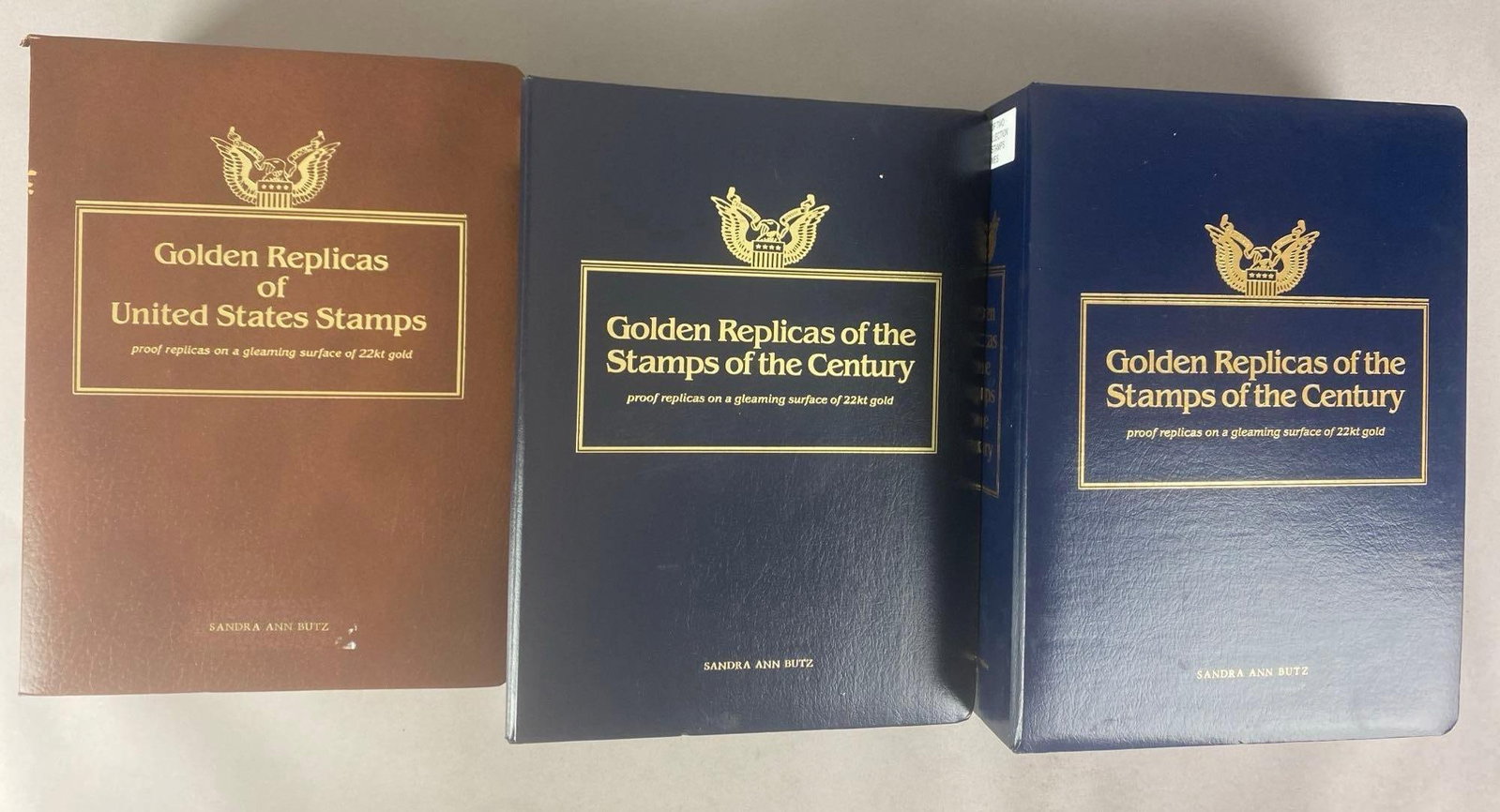 Group of 3 PCS 22K Gold Replicas of Stamps Albums: Postal commemorative Society, largest album measures 14 inches H x 10 inches W x 5 inches D