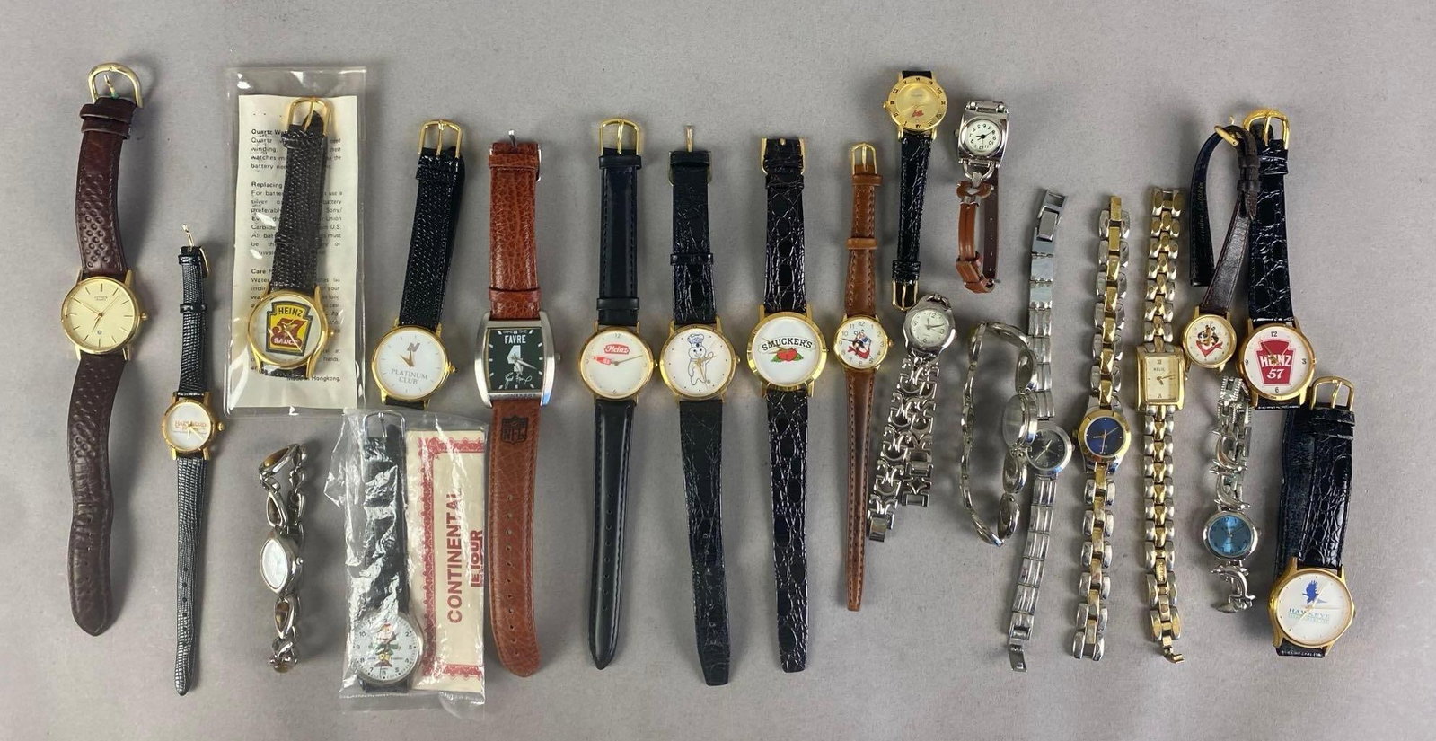 Group of Assorted Wristwatches: Untested. Includes smuckers, heinz, hawkeye food systems and more, longest measures 9 inches in length