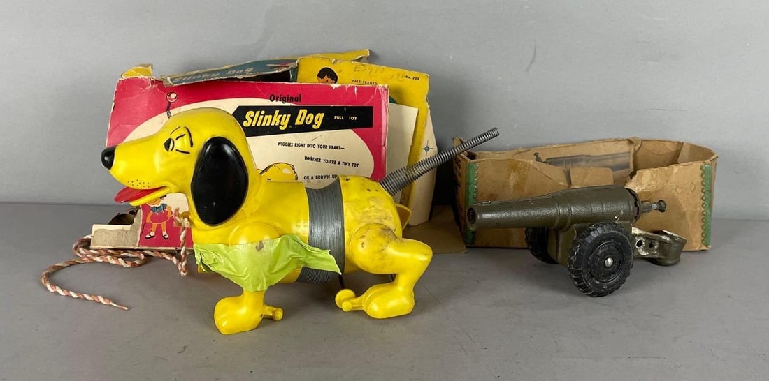 Group of 2 Vintage Toys: Includes slinky dog pull toy - repaired rear leg, separated front leg, big bang model 60mm gun, original damaged packaging