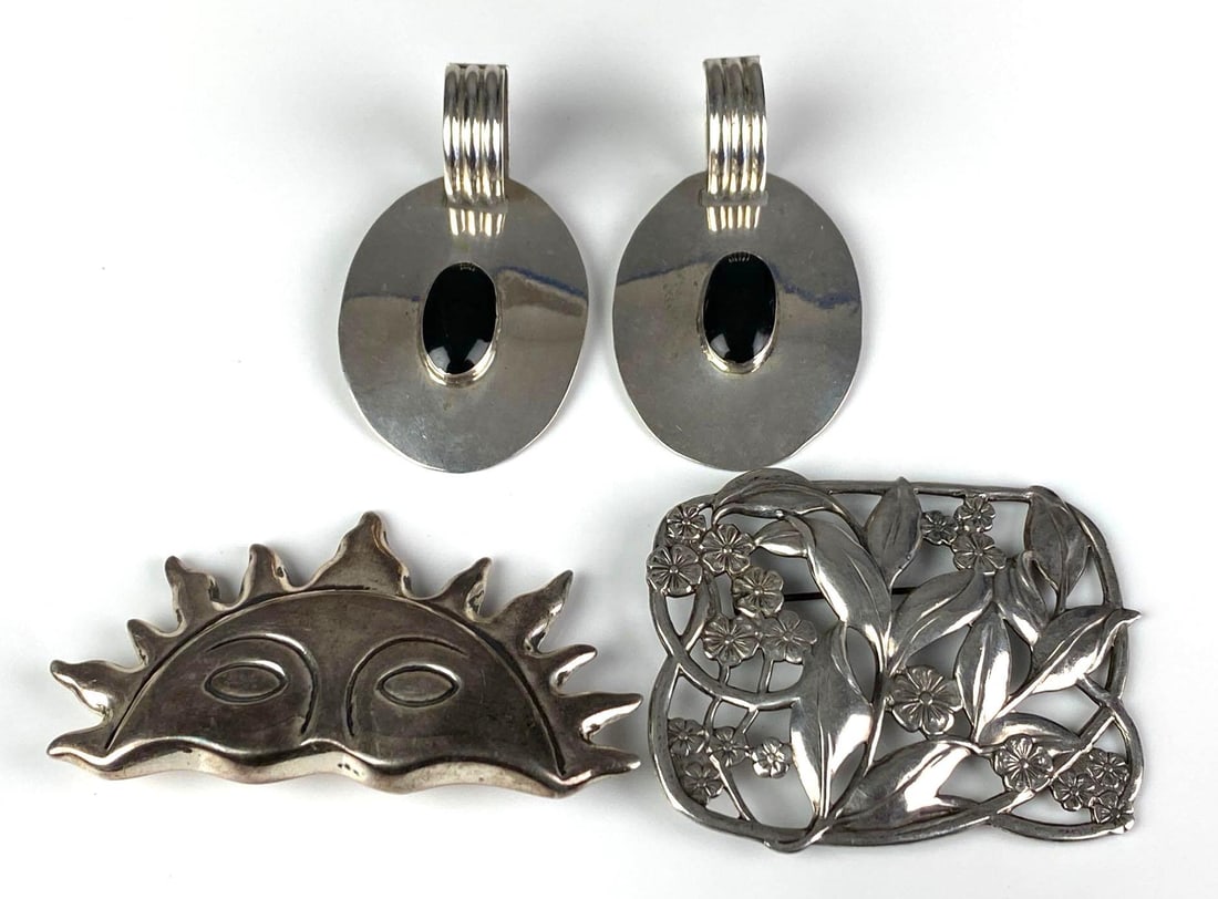 Group of Sterling Silver Brooches and Earrings: Includes pair of Mexican onyx Stud drop earrings, rising sun brooch and floral brooch, largest brooch measures 1 3/4 inches H x 2 1/4 inches W