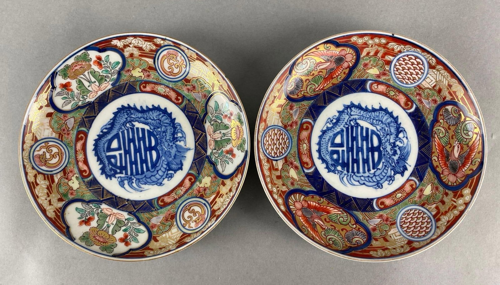 Group of 2 Chinese Imari Porcelain Plates: Painted gold gold dragon and birds, Some small chips, Both measure 7 inches across.