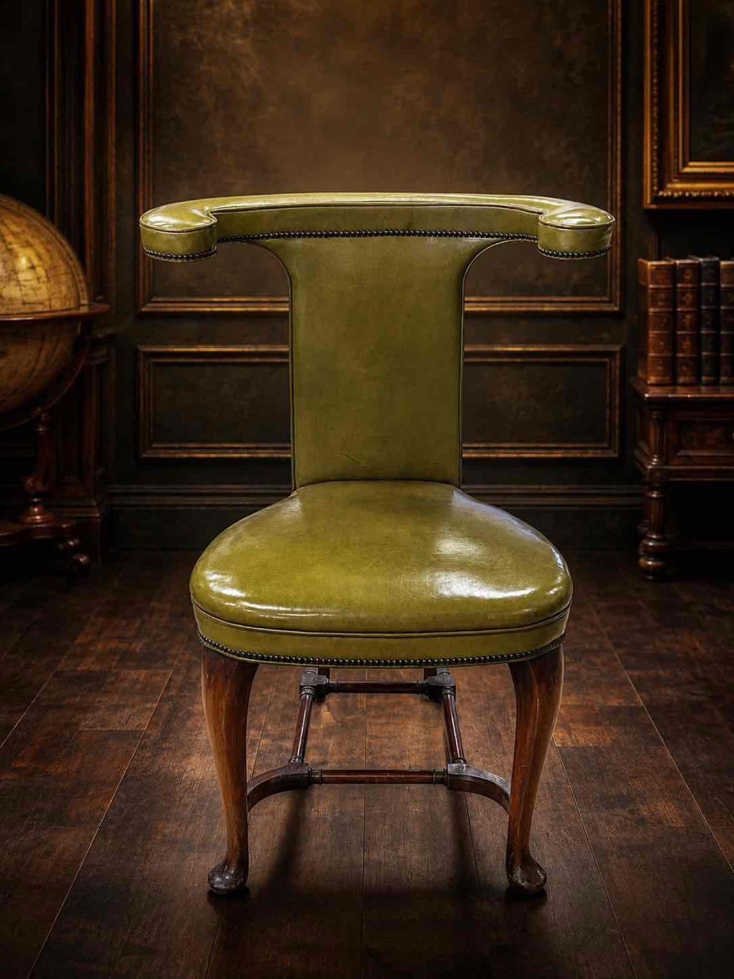 Antique English Mahogany & Green Leather Cockfighting Chair, Georgian Style: A distinctive antique English cockfighting chair featuring a solid mahogany frame with elegant cabriole front legs, H-form stretcher base, and beautifully aged olive green leather upholstery accented