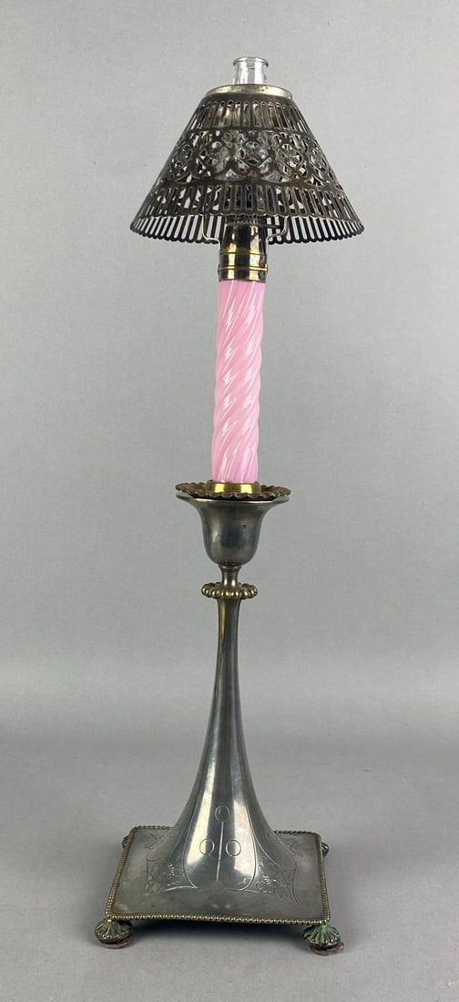 Early 19th Century Pairpoint Silver Plated Candlestick Oil Lamp: Marked on base, Fractures floral motif base, Pink swirl glass column and an openwork shade, Measures 19 1/4 H x 4 1/2 W x 4 1/2 D