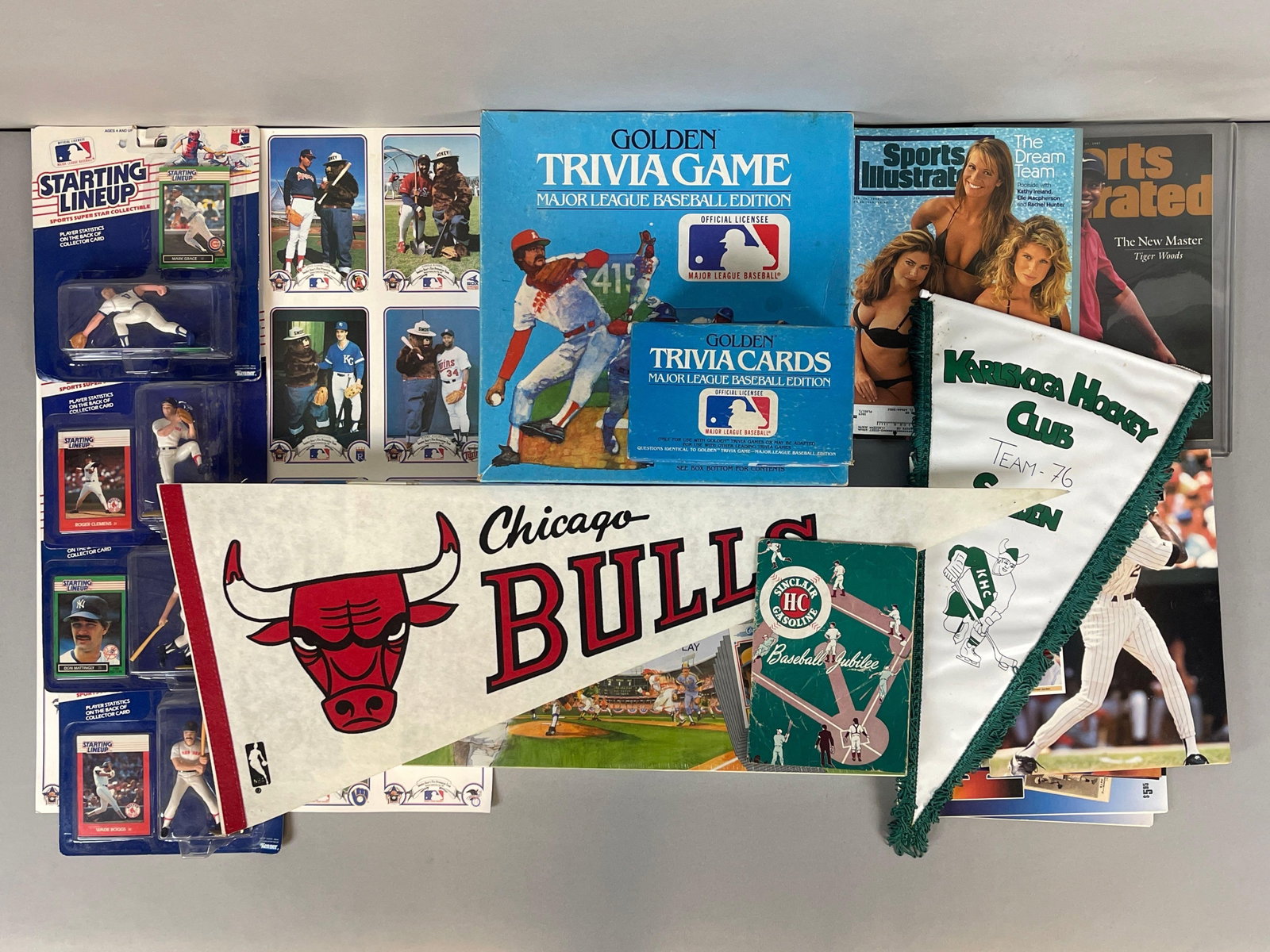 Group of 1980s - 90s Sports Memorabilia, Pennants, and Games: 1980s Chicago Bulls Pennant, 1997 Sports Illustrated Tiger Woods, 1994 Sports Illustrated Swimsuit Edition, 1988 and 89 Starting LineUps, 1987 Smokey the Bear uncut sheet and More
