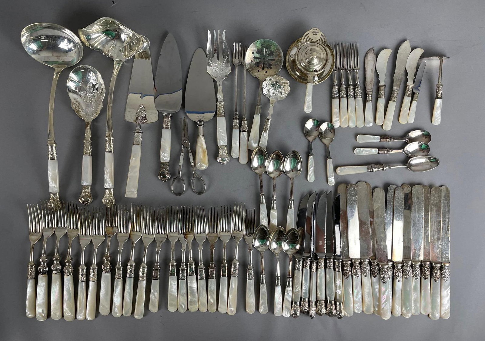 Group of Silver Plated Mother of Pearl Handle Flatware: Includes Marshall fields, American cutlery, Sheffield, largest ladle measures 13 inches long