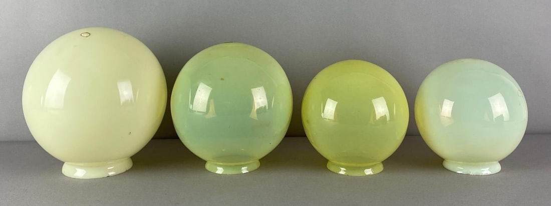 Group of 4 Vaseline Glass Globe Lamp Shades: need cleaning, fleabites on fitters, largest measures 7 1/4 inches H x 6 1/4 inches W with a 3 1/2 inches fitter