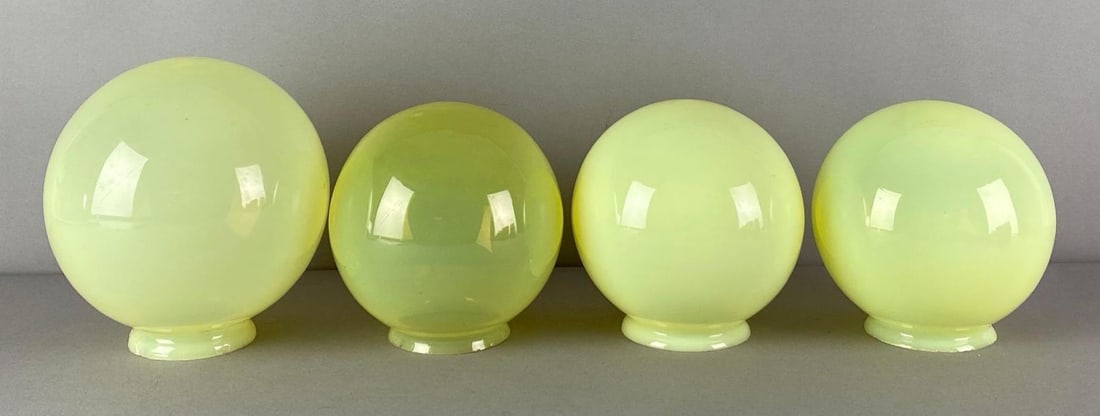 Group of 4 Vaseline Glass Globe Lamp Shades: Fleabites on fitters, largest measures 7 1/2 inches H x 6 1/2 inches W with a 3 inches fitter