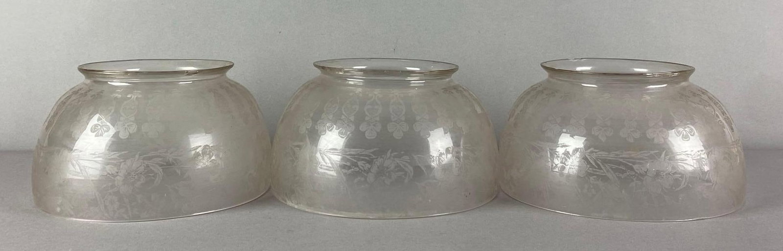 Group of 3 Floral Motif Etched Glass Lamp Shades: Large chips on one shades fitter, each measures 4 inches H x 7 1/2 inches W with a 4 3/4 inches fitter