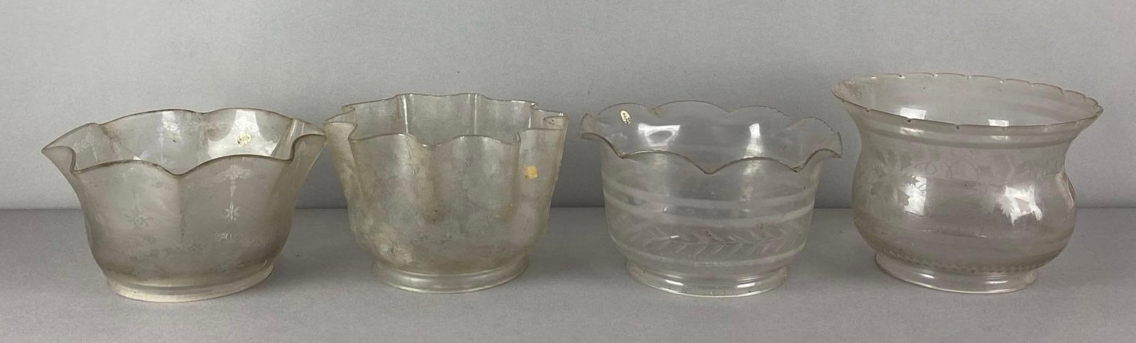 Group of 4 Frosted Floral Etched Glass Lamp Shades: 3 feature ruffled rims, need cleaning, largest measures 5 1/2 H x 8 inches W with a 4 1/2 inches fitter