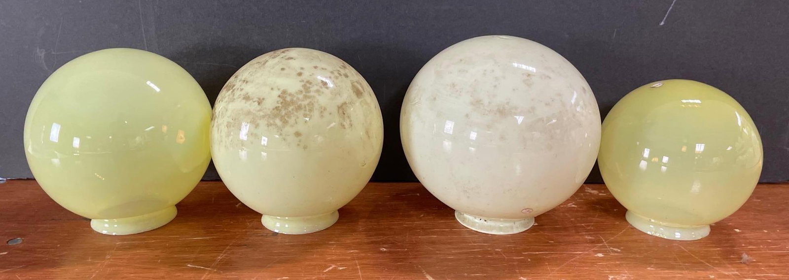 Group of 4 Antique Vaseline Glass Globe Lamp Shades: Largest measures 8 inches , 3 1/4 inches fitters