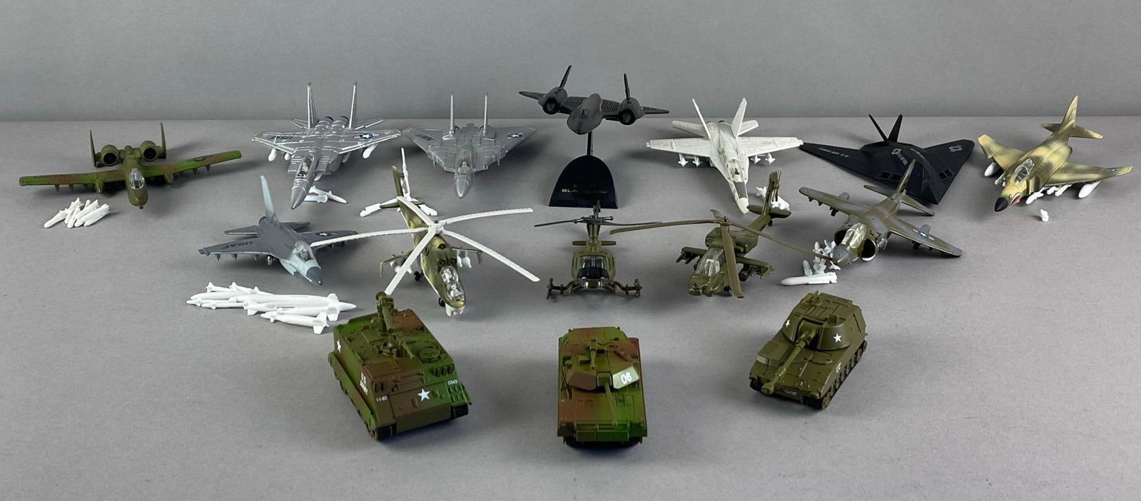 Group of ERTL Die-Cast Model Military Aircraft and Armored Vehicles: inclufed A10 Warthog, SR-71 blackbird, assorted jets and more, blackbird measures 3 1/2 inches H on stand