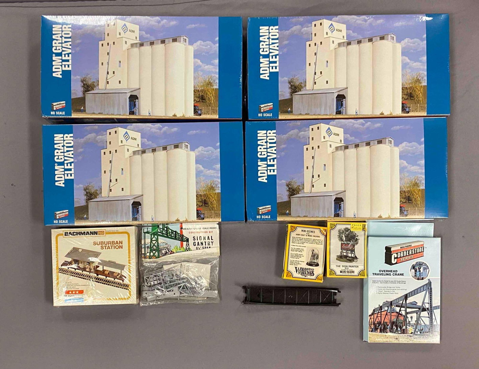 Group of Assorted HO Scale Model Train Building Plastic Model Kits and More: most sealed, includes adm grain elevator, suburban station, signal gantry and more, 9 inches H x 17 1/2 inches D