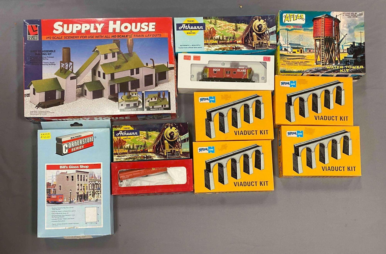 Group of Assorted Model Train Building Plastic Model Kits and More: some sealed, HO/N Scale, includes bills glasa shop, viaduct kits, water tower kit and more, largest measures 9 1/2 inches H x 15 inches W