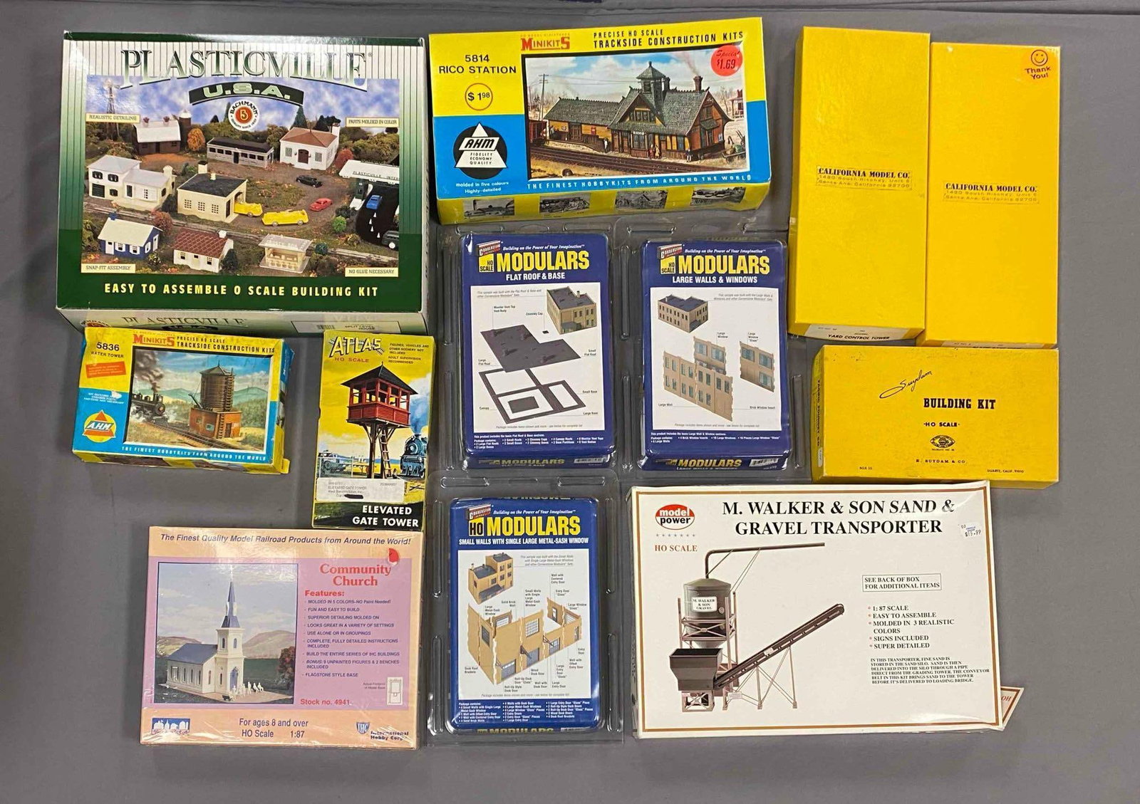 Group of Assorted HO Scale Model Train Building Plastic Model Kits: some sealed, includes community church, elevated gate tower, flat roof and base, largest measured 11 inches H x 14 inches W
